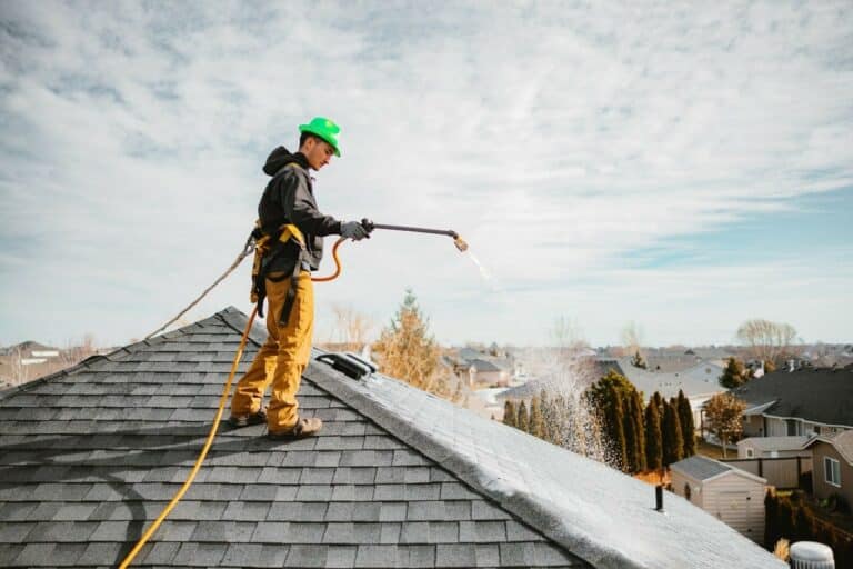 man spraying roof shingle by RoofMaxx Tri-Cities